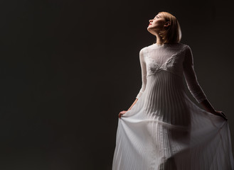 Fototapeta premium Sexy woman in lace white dress. Beautiful girl with blonde hair, perfect makeup. Girl in elegant white dress. Elegant dress concept. Retro blonde lady wearing fashionable white dress. Beauty, fashion.