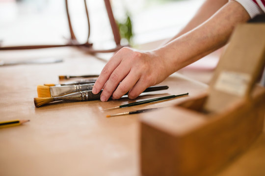 Detail of hands choosing the correct brush
