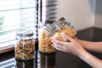 hand hold bottle of macaroni in kitchen
