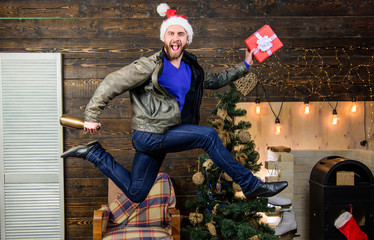 Obraz premium Spread happiness and joy. Bearded guy in motion jump. Delivery christmas present. Still have time. Delivery service. Gifts delivery. Man santa hat hurry to deliver gift on time. Christmas is coming