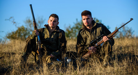 Hunter friend enjoy leisure in field. Hunting with friends hobby leisure. Hunters gamekeepers relaxing. Rest for real men concept. Discussing catch. Hunters with rifles relaxing in nature environment
