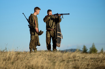Hunters with rifles in nature environment. Hunter friend enjoy leisure in field. Hunting with...