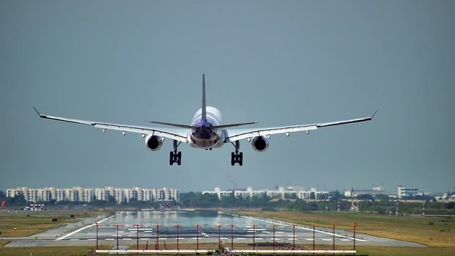 Commercial aeroplane or airliner on a final approaching landing at an International Airport on a clear morning sky