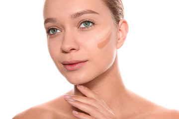 Young woman with different shades of skin foundation on her face against white background