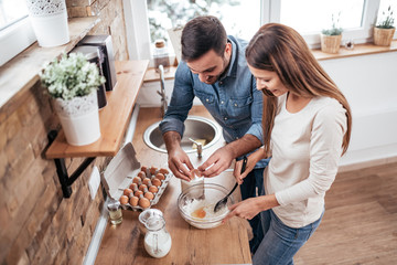 Couple cooking together at home. High angle image.