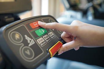 closeup of young woman athlete running on treadmill in gym. push on control panel , stop button.
