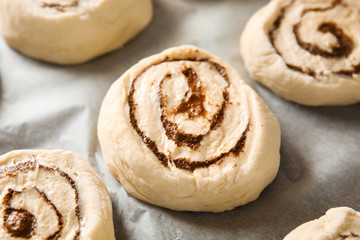 Raw cinnamon rolls on parchment, closeup view