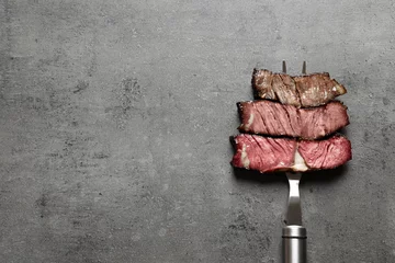 Photo sur Plexiglas Viande Fourchette avec des morceaux de viande grillée délicieuse sur fond gris, vue de dessus. Espace pour le texte