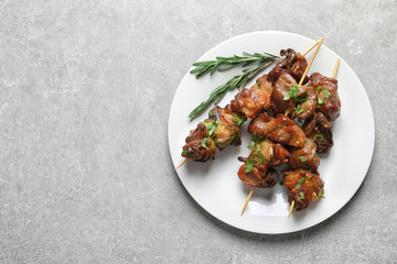 Plate of delicious barbecued meat served on gray table. Space for text