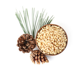 Bowl with pine nuts and cones on white background, top view