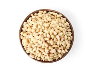 Bowl with pine nuts on white background, top view