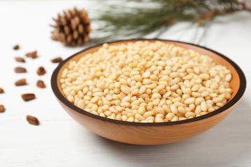 Plate with pine nuts on wooden table