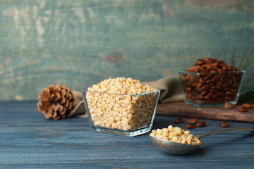 Spoon and bowl with pine nuts on wooden table