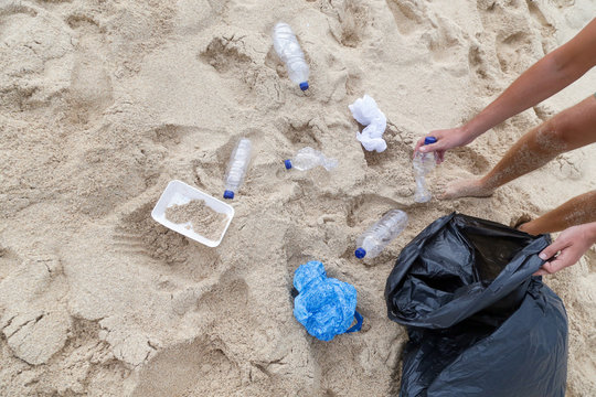 Volunteer man collecting trash from the beach. Trash-free seas concept. Single-use plastic is a human addiction that is destroying our planet