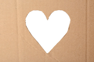 Heart shaped hole in cardboard on white background. Eco friendly material