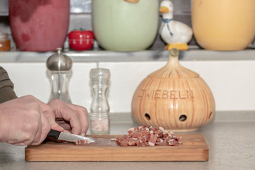 Mann schneidet speck für Rinderrouladen