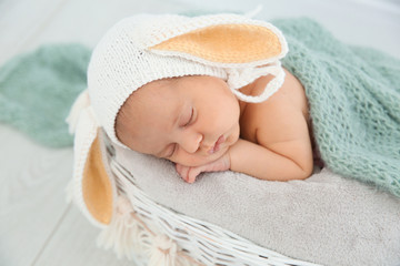 Adorable newborn child wearing bunny ears hat in baby nest