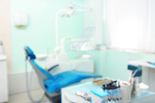 Blurred view of dentist's office with chair and professional equipment