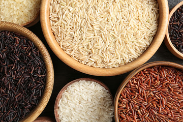 Flat lay composition with brown and other types of rice in bowls