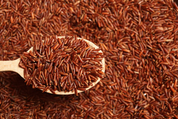 Brown rice in wooden spoon, closeup view