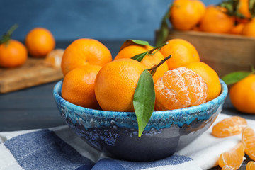 Fresh ripe tangerines in bowl on table