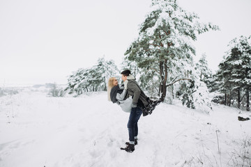 Happy Couple Having Fun Outdoors in Snow Park.