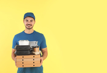 Young courier with different orders on color background, space for text. Food delivery service
