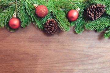 Fototapeta na wymiar Christmas background. Fir tree branches, red Christmas ball and pine cones with decoration on a wooden board. with copy space for text.