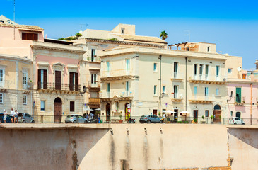 Fototapeta na wymiar View of old street, facades of ancient buildings in seafront of Ortygia (Ortigia) Island, Syracuse, Sicily, Italy.
