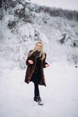 Fototapeta na wymiar portrait of a young blonde girl in winter forest