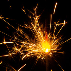 Christmas sparkler isolated on black background. Bengal fire