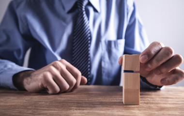 Fototapeta na wymiar Businessman holding wooden cube on a wooden table.