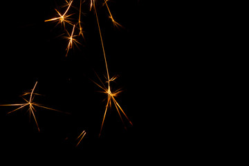 Christmas sparkler isolated on black background. Bengal fire