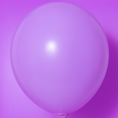 Purple balloon on a purple background with shadow. Side glare.