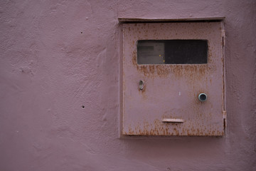 Vintage texture pink mailbox on a pink concrete wall