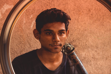 Portrait of boy behind the spinning bicycle wheel