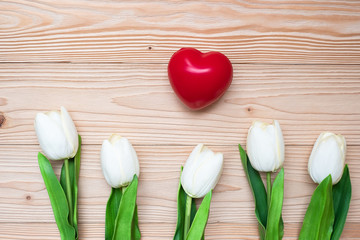 Top view white tulip flowers with red heart shape on wooden table. love, romantic and Valentine Day holiday Concept