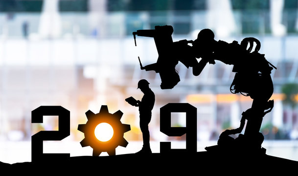 2019 years of robot assistant technology , industry 4.0 , artificial intelligence trend concept. Silhouette of business man control automation robo advisor arm in blur smart building bakckground.