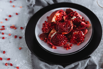 Top view cut into pieces red garnet in a dish on the table, closeup