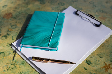 blank note paper and pen.copy space for your text and writing concept.gold pen on wooden table.diary, goals and plans for the new year.Back to school and education concept. Selective focus