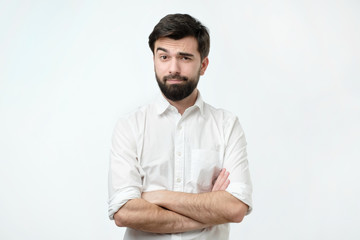 Portrait of a mature man with a beard looking suspicious. Person lifts his eyebrow and do not really believe in the words he hears, looking a little bit gloomy.