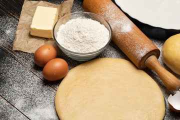rolled and unbaked Shortcrust pastry dough recipe on wooden background
