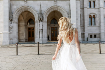 Bride and groom hugging in the old town street. Wedding couple in love. Luxury rhinestone dress.