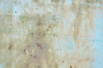 An old metal shield is painted gray with rust and cracks.