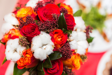 Beautiful bridal bouquet of flowers. Red roses and cotton in bouquet for bride