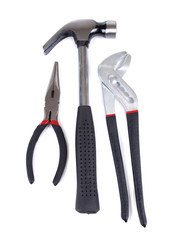 Metal screwdriver and hammer on white background