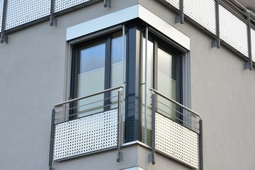 Glastüren mit Metall-Sicherheits-Geländer an moderner Neubau-Hausfront © Hermann