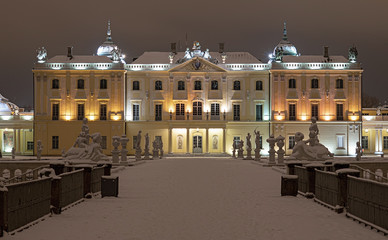 Branicki Palace in Bialystok at night in winter scenery. Snow-covered garden and walls of the palace highlighted with stylish lamps.