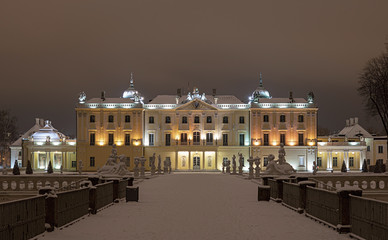 Branicki Palace in Białystok in Poland at night in winter scenery. Snow-covered garden and walls of the palace highlighted with stylish lamps.