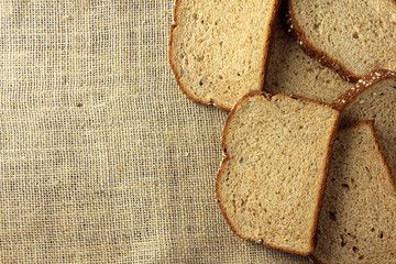 Wholegrain sliced organic bread composed of oats and flax seeds on wooden table. Copy space